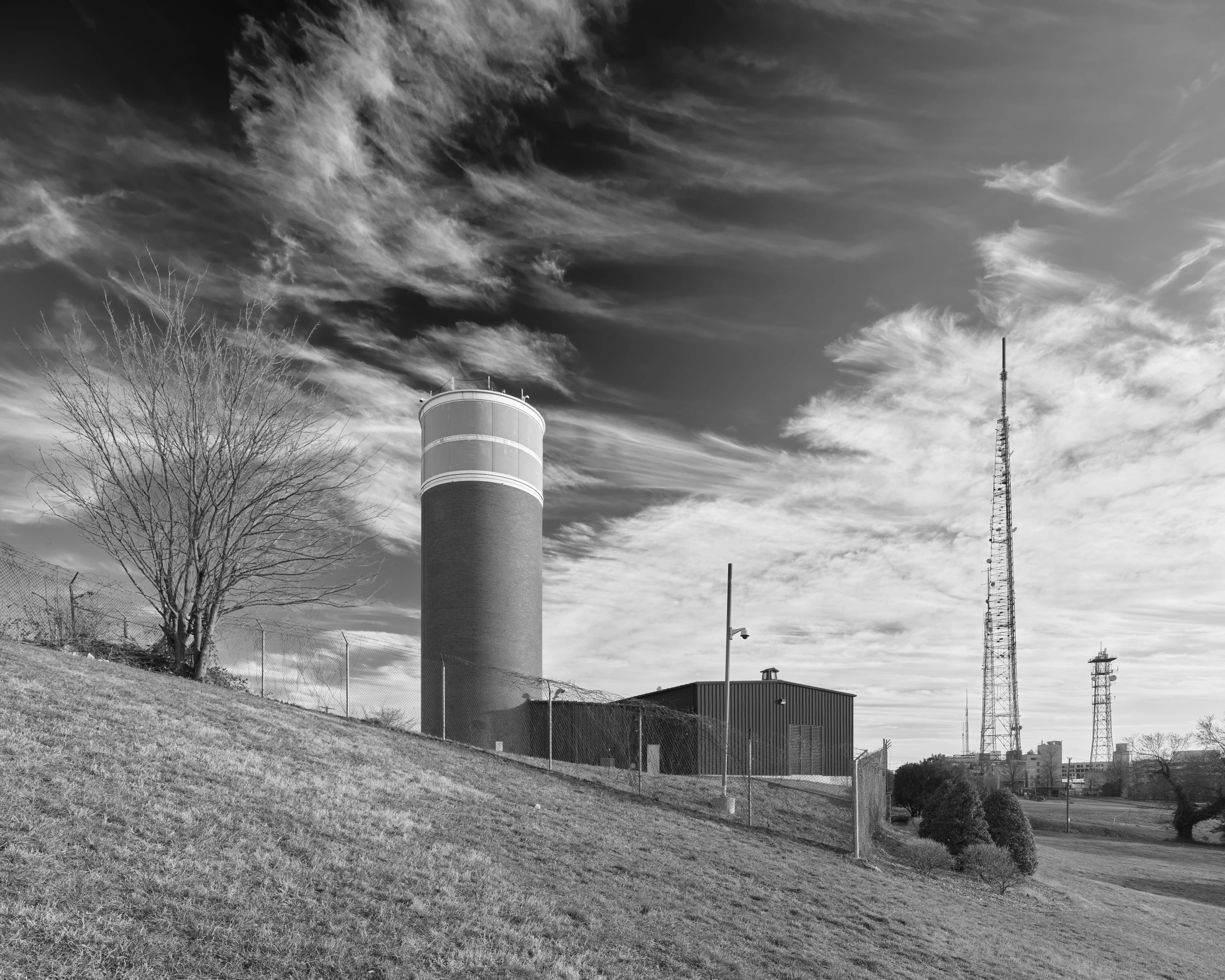 A 100 foot hardened windowless concrete tower stand against a slopped foreground.